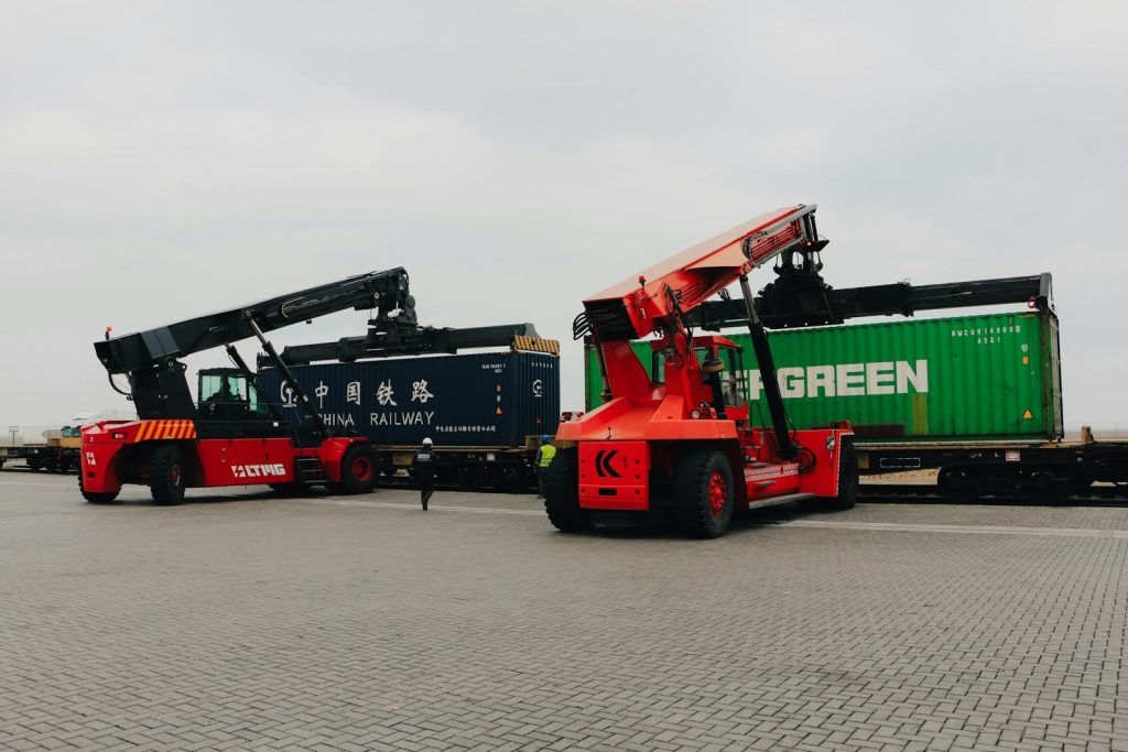 Forklifts unload cargo containers from trains.